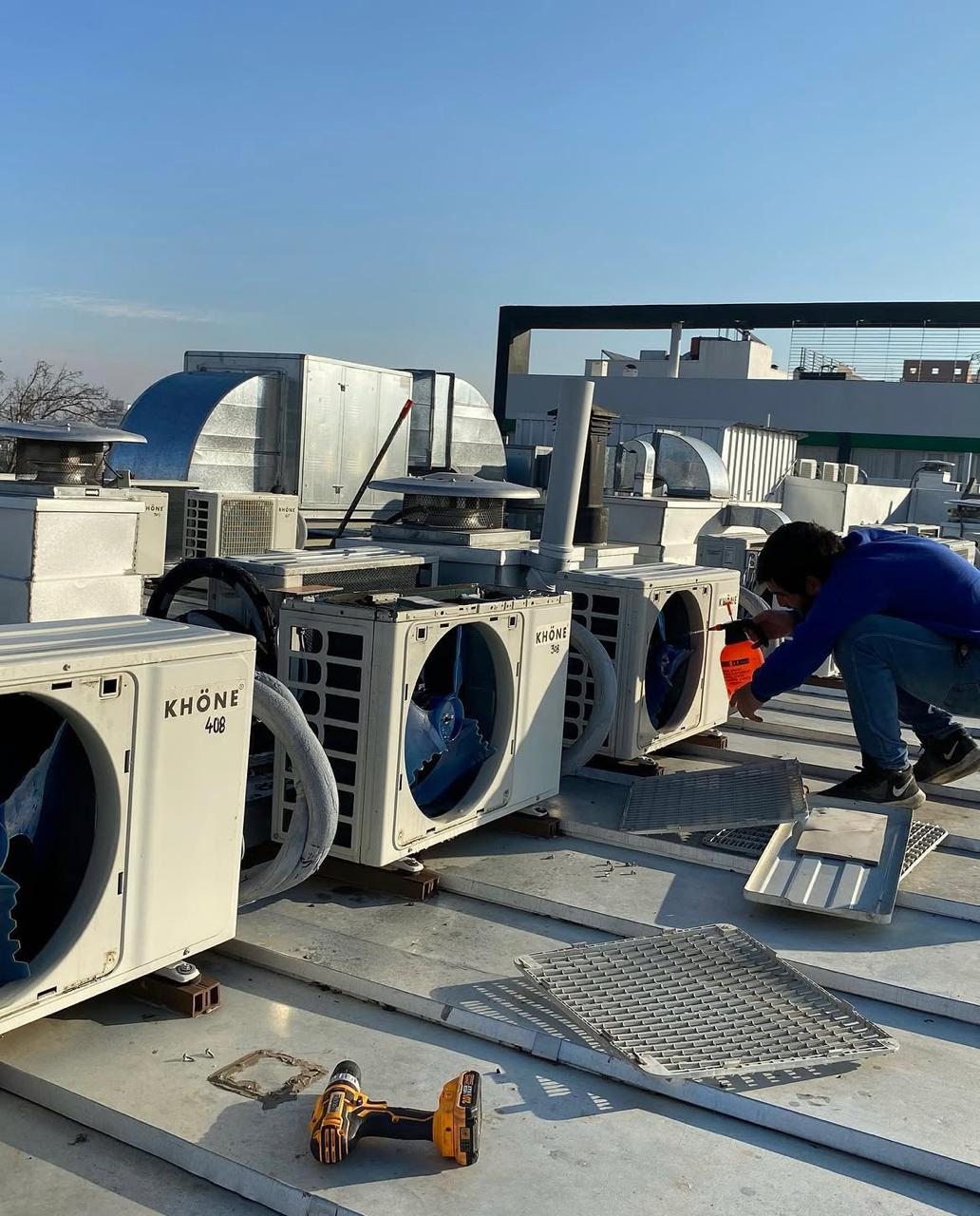 Técnico realizando mantenimiento de unidades exteriores en techo